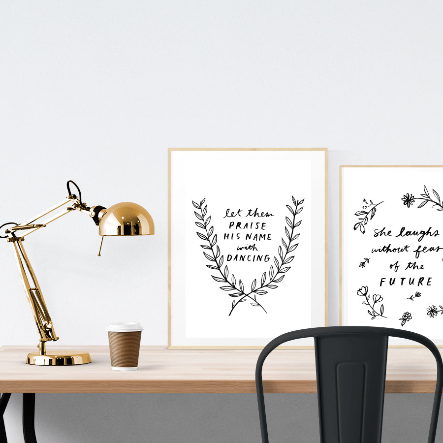 A3 beautiful calligraphy poster placed standing next to a smaller A4 sized calligraphy poster on a wooden table. Modern home interior design ideas.