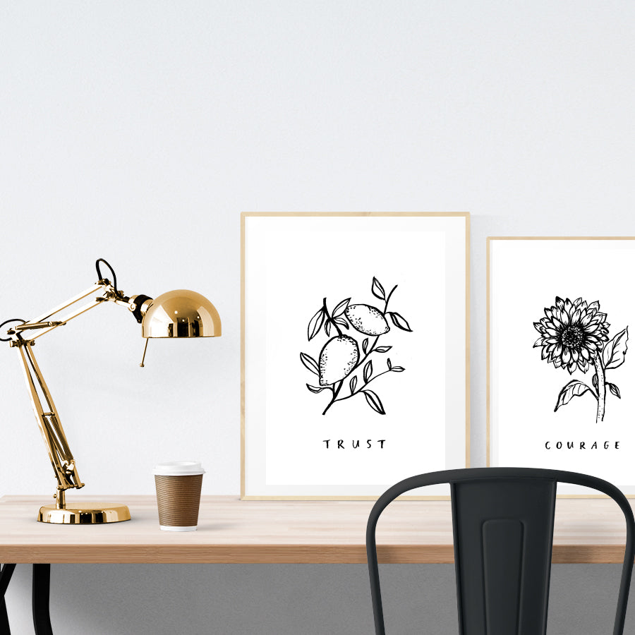 A3 beautiful calligraphy poster placed standing next to a smaller A4 sized calligraphy poster on a wooden table. Simple Christian home interior design ideas.