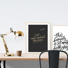 A3 beautiful calligraphy poster placed standing next to a smaller A4 sized calligraphy poster on a wooden table. Modern home interior design ideas.