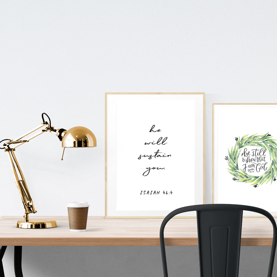 A3 beautiful calligraphy poster placed standing next to a smaller A4 sized calligraphy poster on a wooden table. Modern home interior design ideas. Minimalistic home decor.