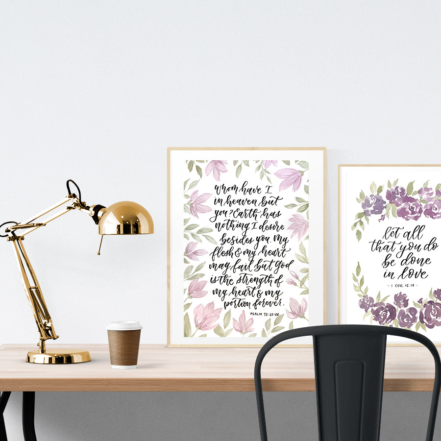 A3 beautiful calligraphy poster placed standing next to a smaller A4 sized calligraphy poster on a wooden table. Rustic Christian home interior design ideas.