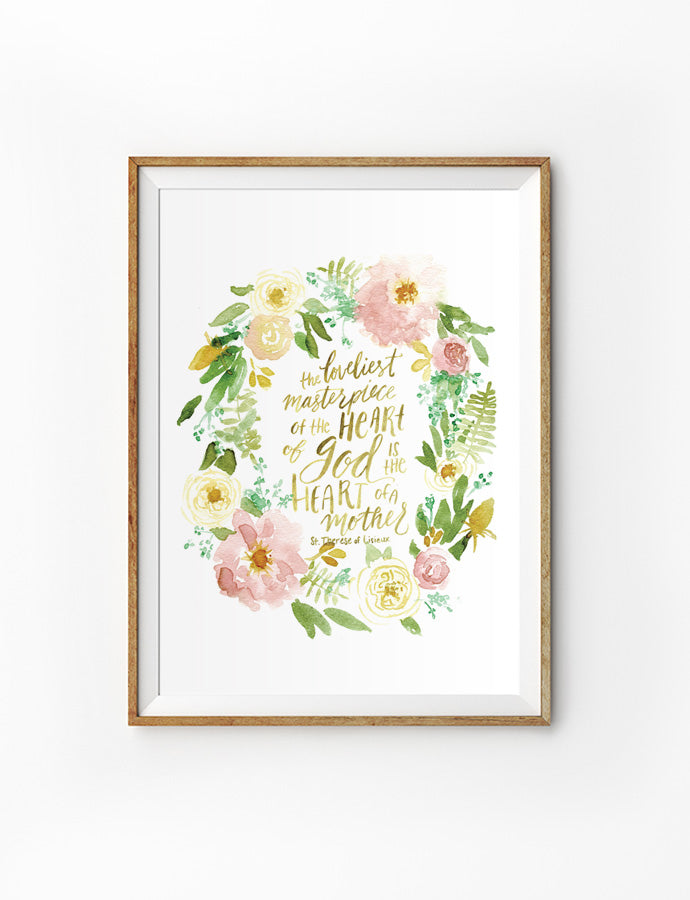 Poster featuring beautiful typography bible verses with flower wreath designs ‘the loveliest masterpiece of the heart of God is the heart of a mother’ is hung on the wall in a gold photo frame’. 200GSM paper, available in A3,A4 size.