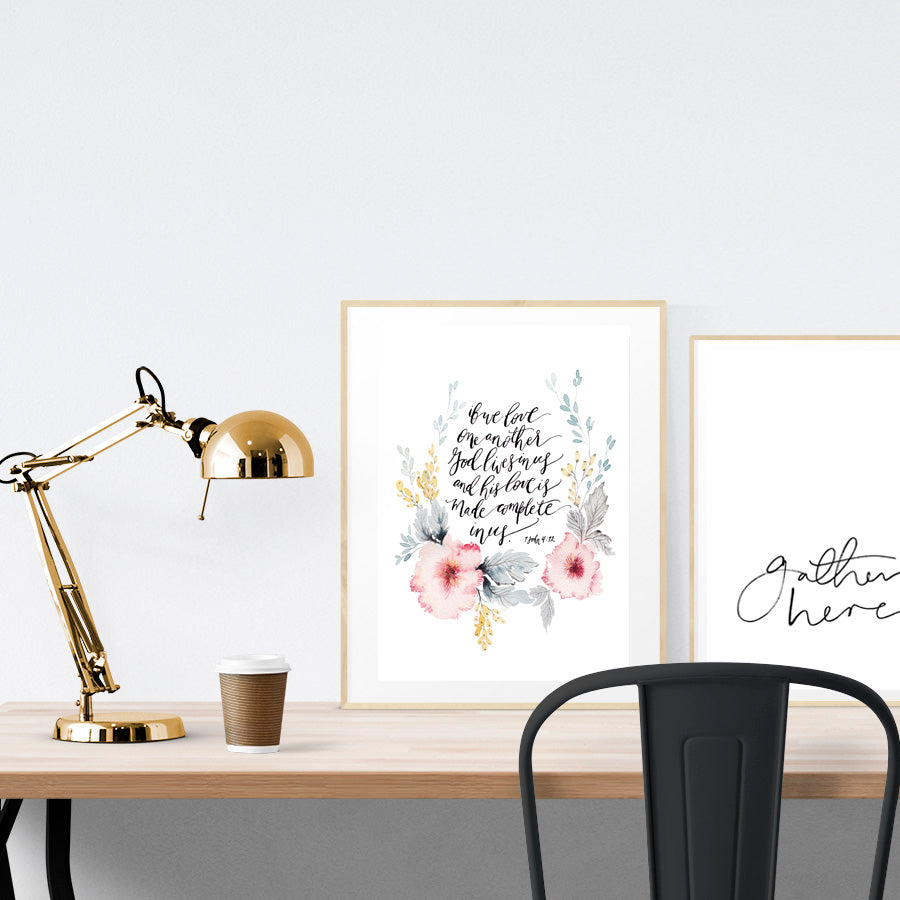 A3 beautiful flower calligraphy poster placed standing next to a smaller A4 sized calligraphy poster on a wooden table. Modern home interior design ideas.