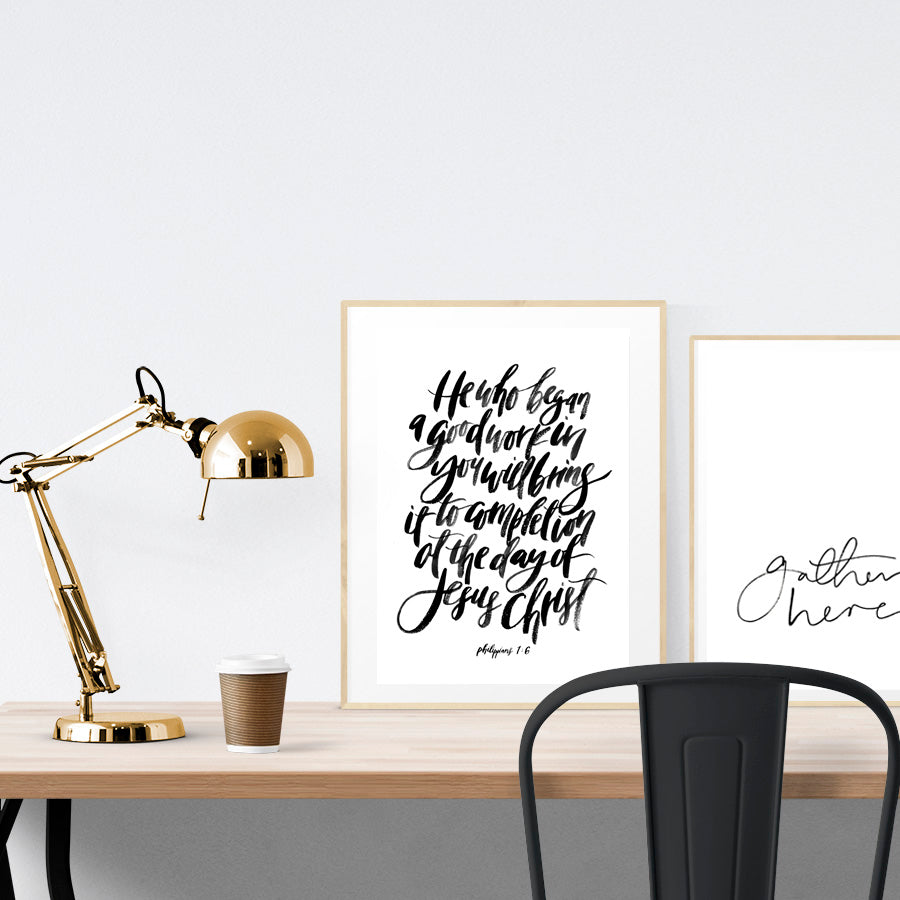 A3 beautiful calligraphy poster placed standing next to a smaller A4 sized calligraphy poster on a wooden table. Minimalistic decor, Modern home interior design ideas.