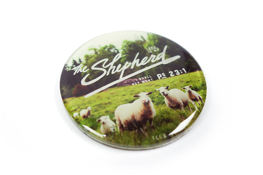 Close up of 5.5 cm diameter circular Acrylic fridge magnet with bible verse “The Lord is my shepherd I shall not want” on sheep and grassland background.