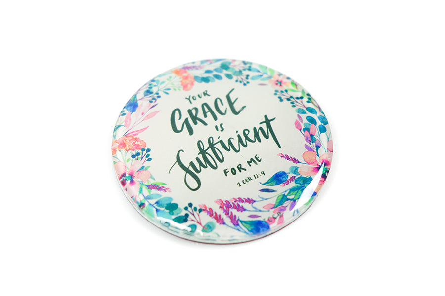 Close up of 5.5 cm diameter circular Acrylic fridge magnet with bible verse “Your grace is sufficient” on flowers background.