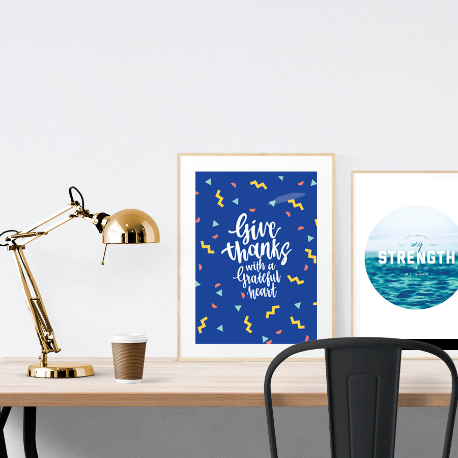 A3 calligraphy poster placed standing next to a smaller A4 sized calligraphy poster with on a wooden table. Inspiring home decor ideas.