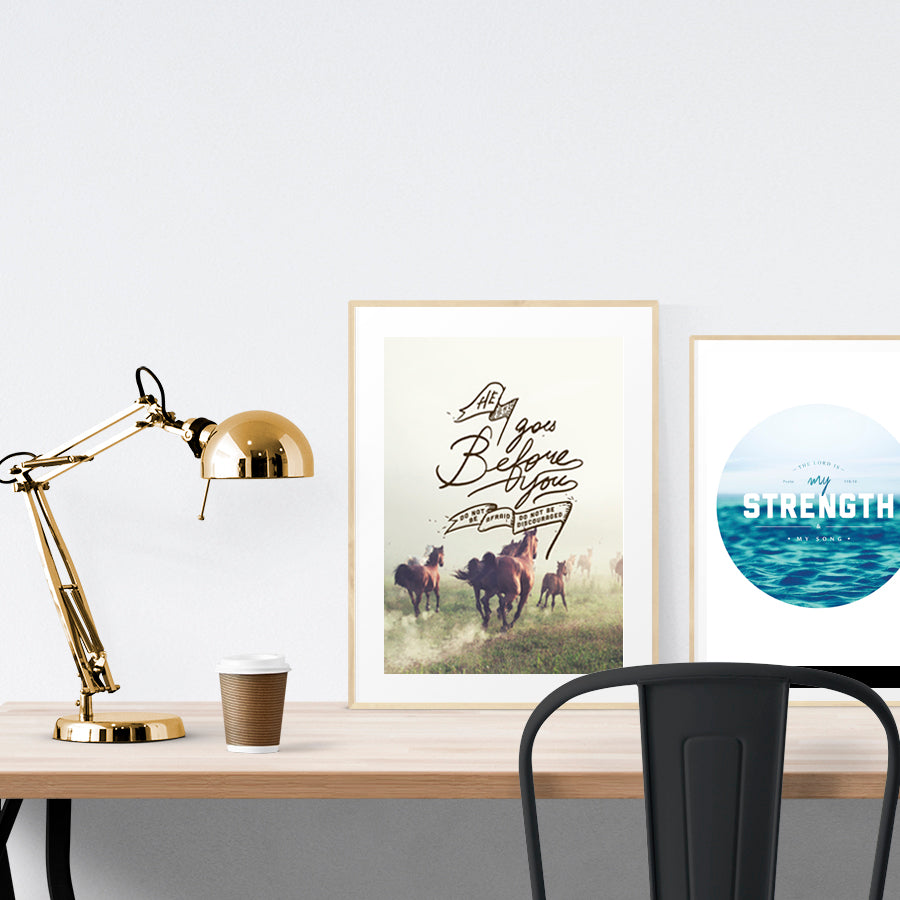 A3 beautiful painting poster placed standing next to a smaller A4 sized water theme calligraphy poster on a wooden table. Inspiring home decor ideas.