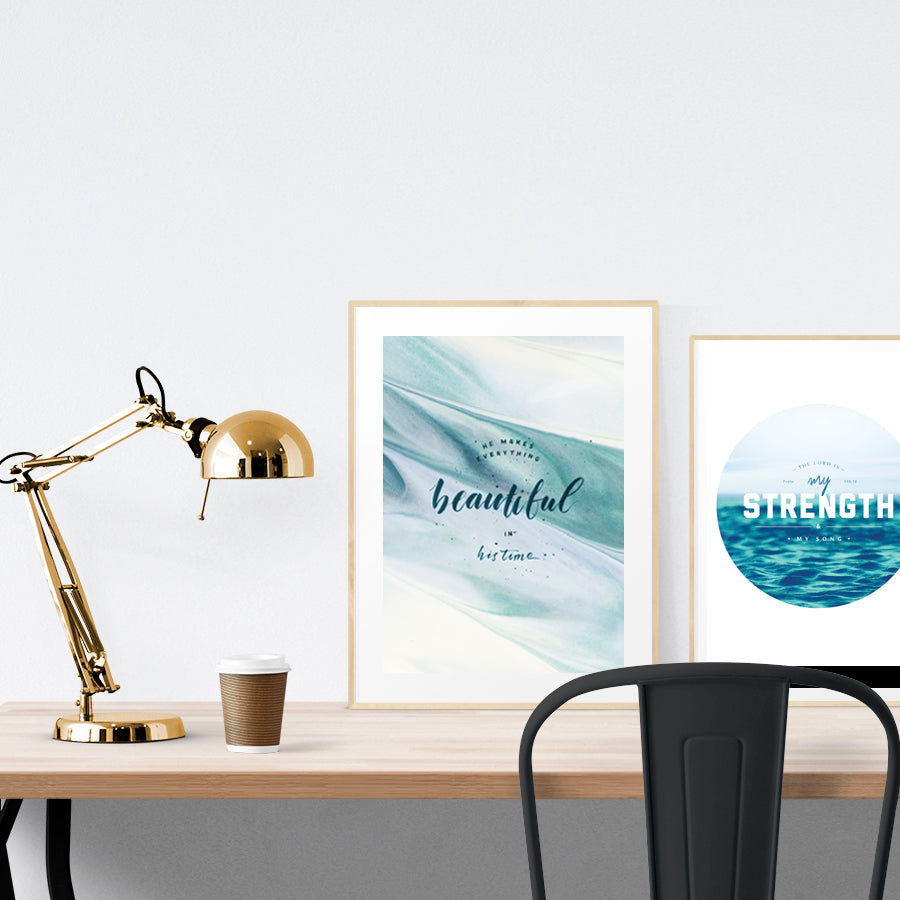 A3 beautiful calligraphy poster placed standing next to a smaller A4 sized calligraphy poster on a wooden table. Modern home interior design ideas.