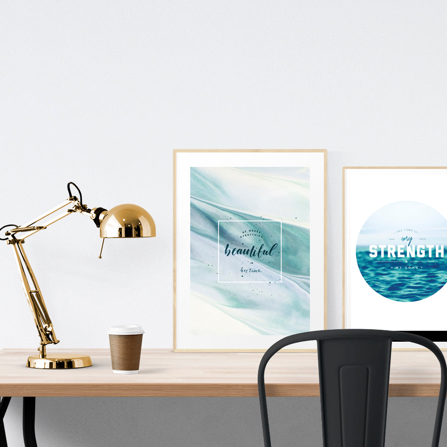 A3 beautiful calligraphy poster placed standing next to a smaller A4 sized calligraphy poster on a wooden table. Modern home interior design ideas.
