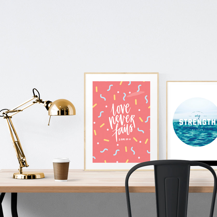 A3 beautiful calligraphy poster placed standing next to a smaller A4 sized calligraphy poster on a wooden table. Modern home interior design ideas.