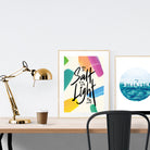 A3 beautiful calligraphy poster placed standing next to a smaller A4 sized calligraphy poster on a wooden table. Modern home interior design ideas.