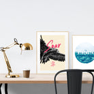 A3 beautiful calligraphy poster placed standing next to a smaller A4 sized calligraphy poster on a wooden table. Minimalistic home interior design ideas.