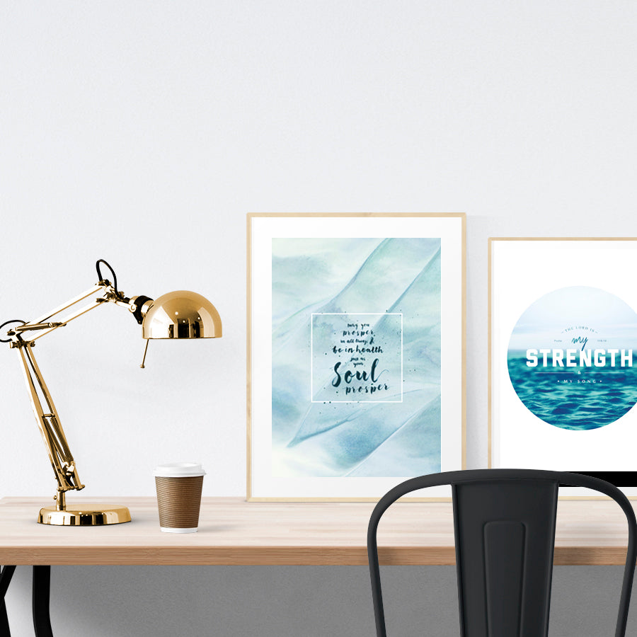 A3 beautiful calligraphy poster placed standing next to a smaller A4 sized calligraphy poster on a wooden table. Calm home interior design ideas.
