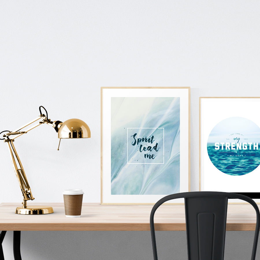 A3 beautiful calligraphy poster placed standing next to a smaller A4 sized calligraphy poster on a wooden table. Calm home interior design ideas.