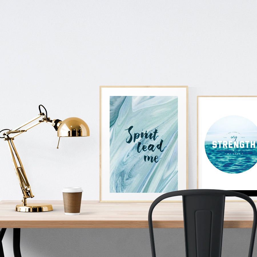 A3 beautiful calligraphy poster placed standing next to a smaller A4 sized calligraphy poster on a wooden table. Calm home interior design ideas.