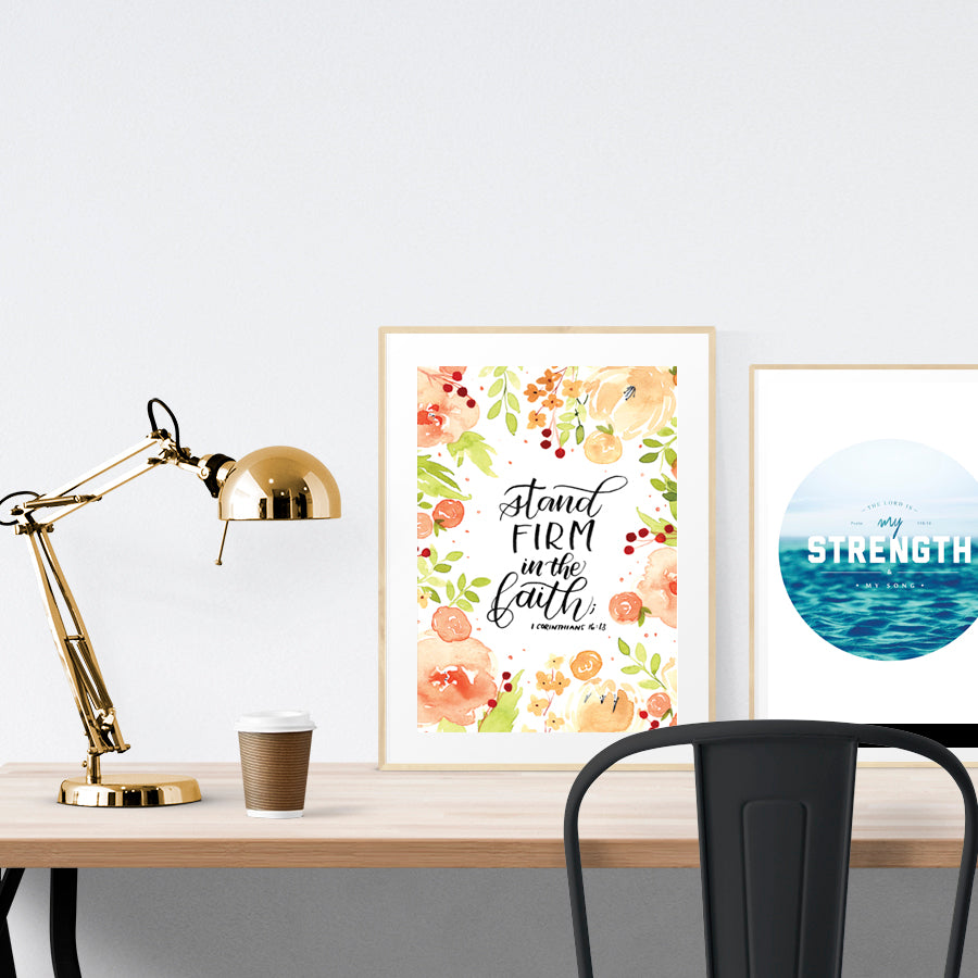 A3 beautiful calligraphy poster placed standing next to a smaller A4 sized calligraphy poster on a wooden table. Rustic home interior design ideas.