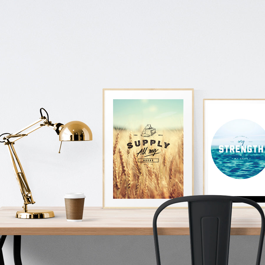 A3 beautiful calligraphy poster placed standing next to a smaller A4 sized calligraphy poster on a wooden table. Minimalistic home interior design ideas.