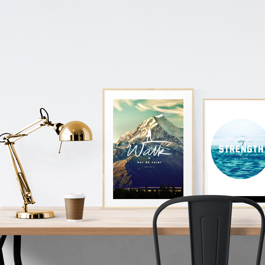 A3 beautiful calligraphy poster placed standing next to a smaller A4 sized calligraphy poster on a wooden table. Modern Christian home interior design ideas.