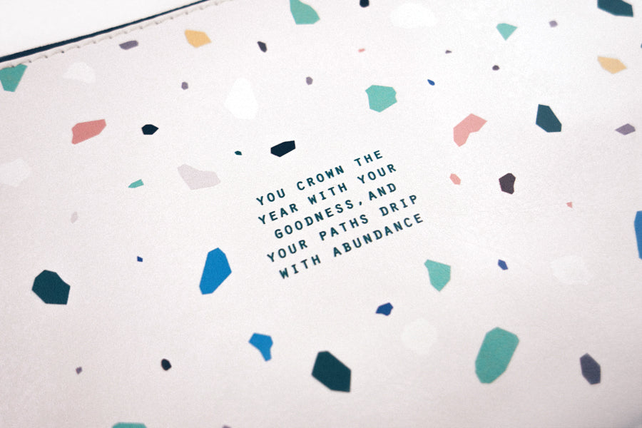 bible verse ‘ you crown the year with your goodness, and your paths drip with abundance' in blue lettering 